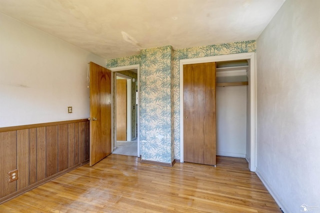 unfurnished bedroom with a closet and light wood-style floors