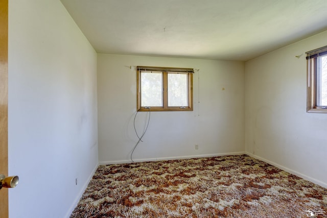 carpeted spare room featuring baseboards