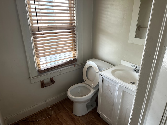bathroom with toilet, wood finished floors, and vanity