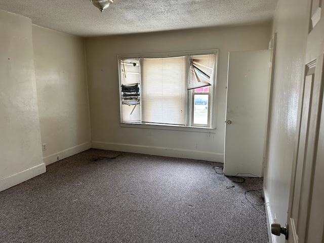 unfurnished room with baseboards, carpet flooring, and a textured ceiling