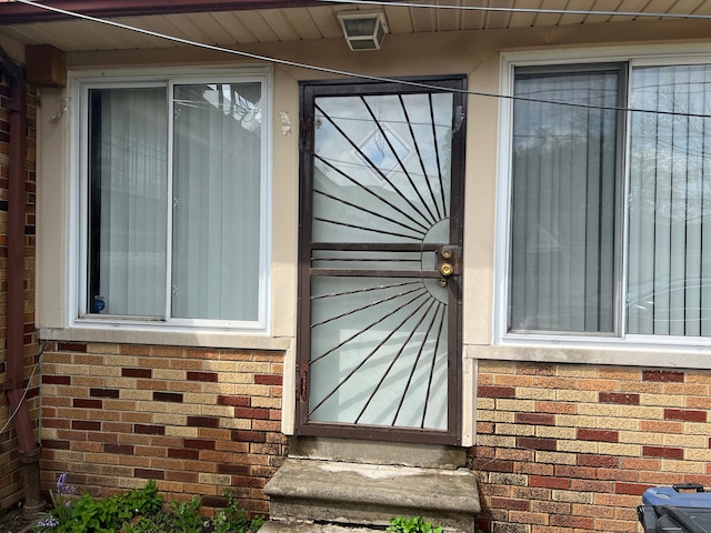 view of exterior entry featuring brick siding