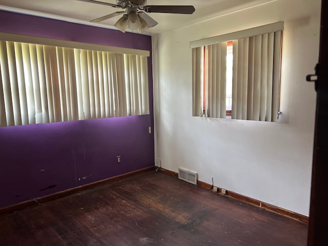 empty room featuring a ceiling fan, wood finished floors, and baseboards