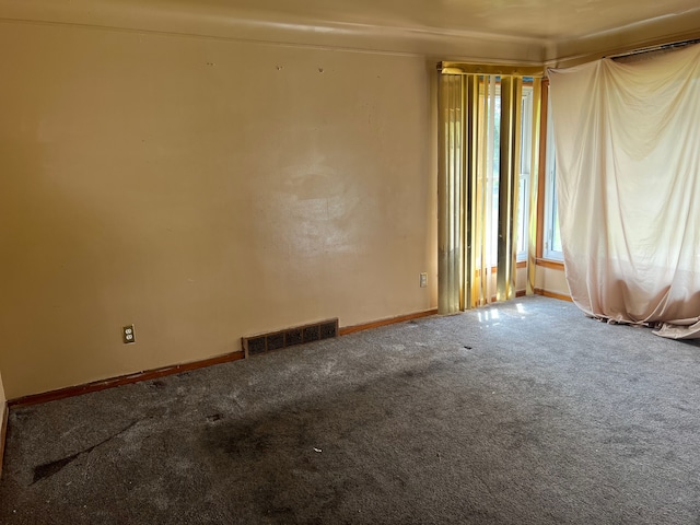 carpeted spare room featuring baseboards
