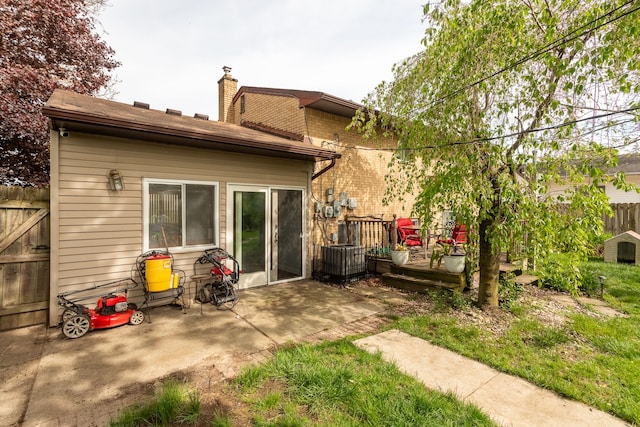 back of property featuring fence, a chimney, a patio area, and a deck