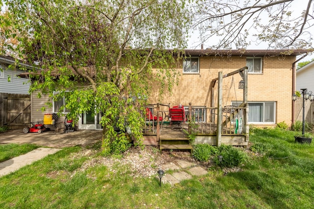 rear view of house featuring brick siding and a deck