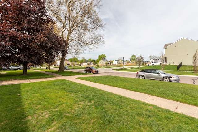 view of grassy yard with a residential view