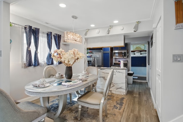 dining space featuring wood finished floors, recessed lighting, healthy amount of natural light, baseboards, and ornamental molding