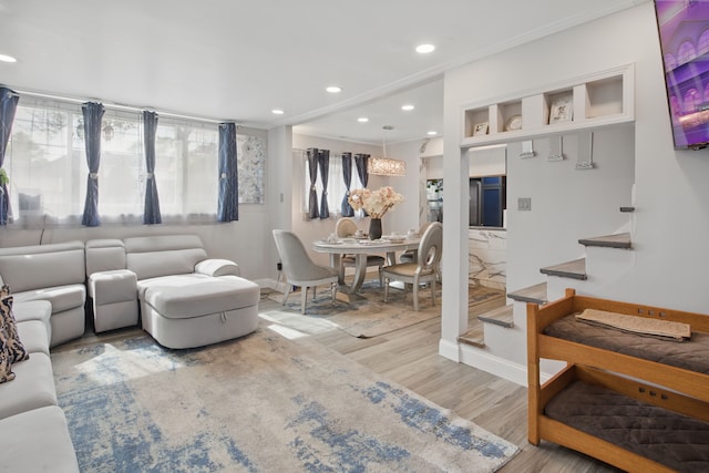 living area featuring stairway, wood finished floors, recessed lighting, baseboards, and crown molding