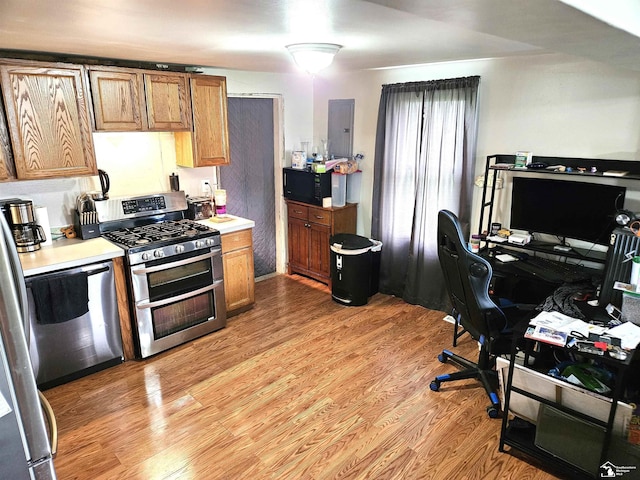 kitchen with light countertops, brown cabinetry, light wood-style flooring, and double oven range