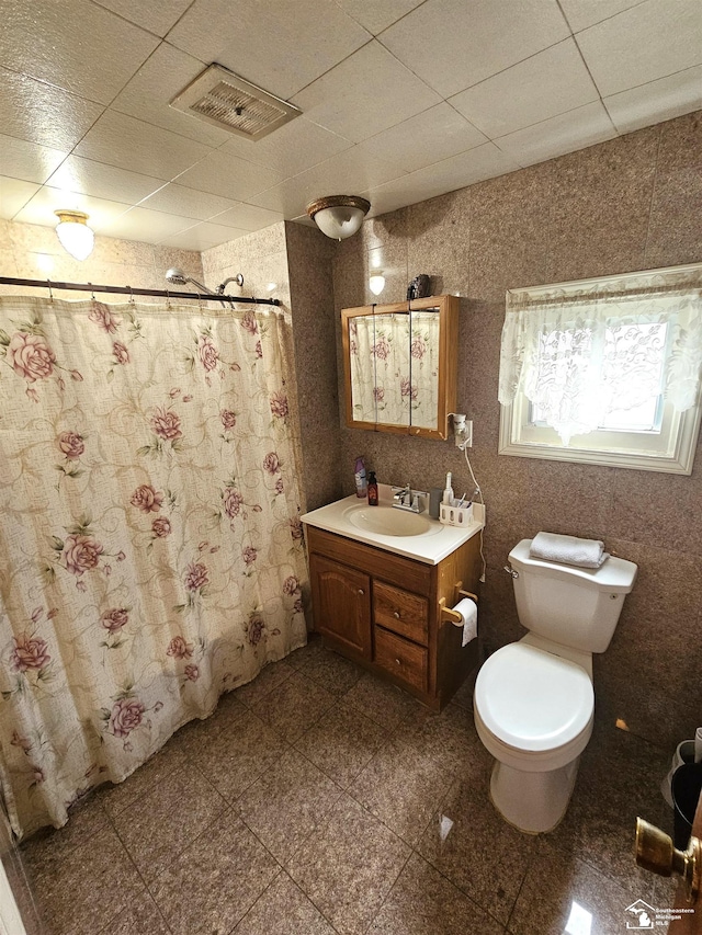 full bathroom featuring a shower with curtain, toilet, vanity, and visible vents