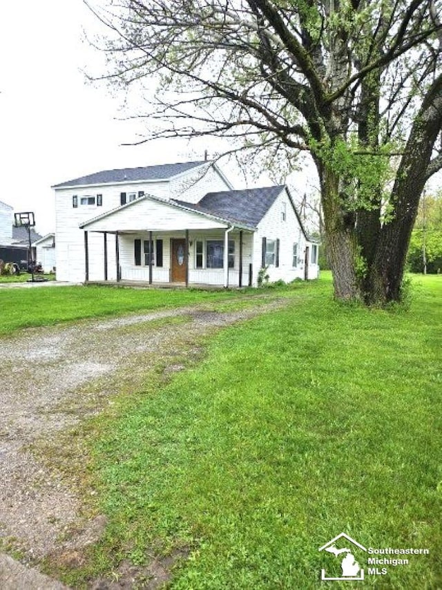 view of front of home featuring a porch, driveway, and a front yard