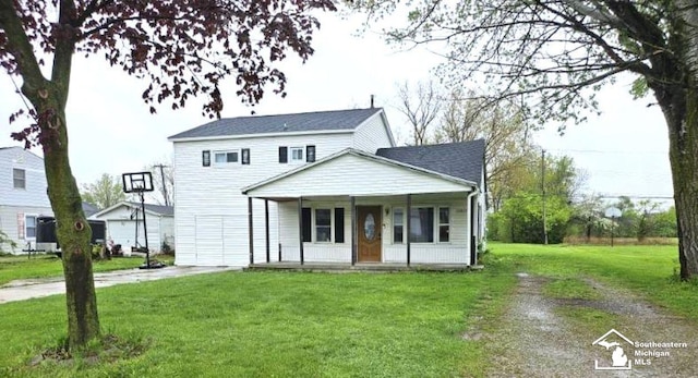 traditional home with driveway, covered porch, and a front yard