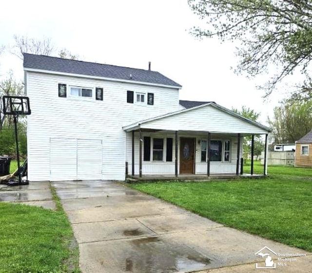 view of front of property with covered porch, concrete driveway, and a front yard