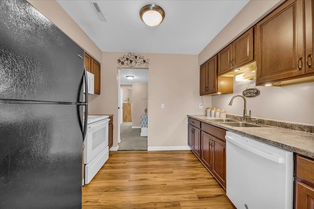 kitchen featuring a sink, brown cabinetry, visible vents, white appliances, and light wood-style floors