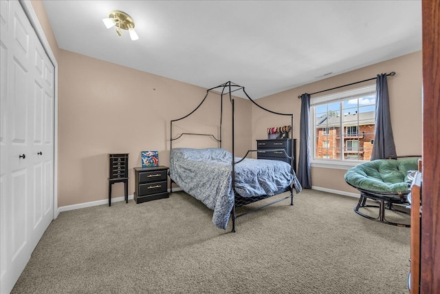 carpeted bedroom with baseboards and a closet