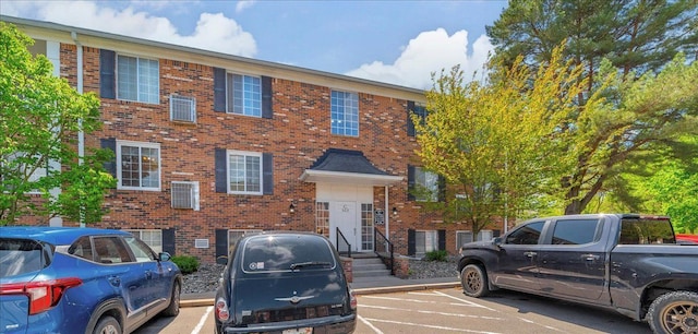 townhome / multi-family property featuring uncovered parking and brick siding