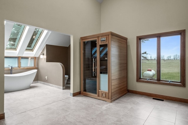 3101 Delano Rd, Oxford, MI 48371 - additional living space with a skylight, baseboards, a towering ceiling, and light tile patterned flooring