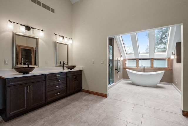 3101 Delano Rd, Oxford, MI 48371 - full bathroom with a skylight, baseboards, a shower stall, double vanity, and a freestanding tub