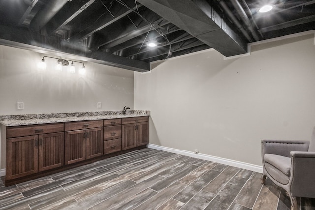 3101 Delano Rd, Oxford, MI 48371 - finished basement with dark wood finished floors, bar with sink, and baseboards