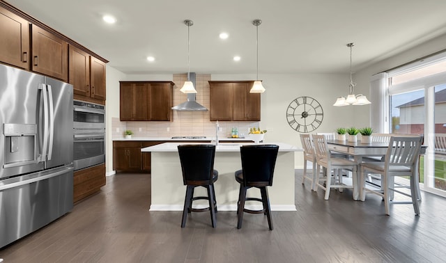 43547 Bolingbrooke Ln, Novi, MI 48377 - kitchen with appliances with stainless steel finishes, wall chimney exhaust hood, backsplash, light countertops, and dark wood-style flooring