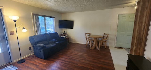 5608 Clifford St, Topinabee, MI 49791 - living area with wood finished floors, a textured ceiling, and baseboards