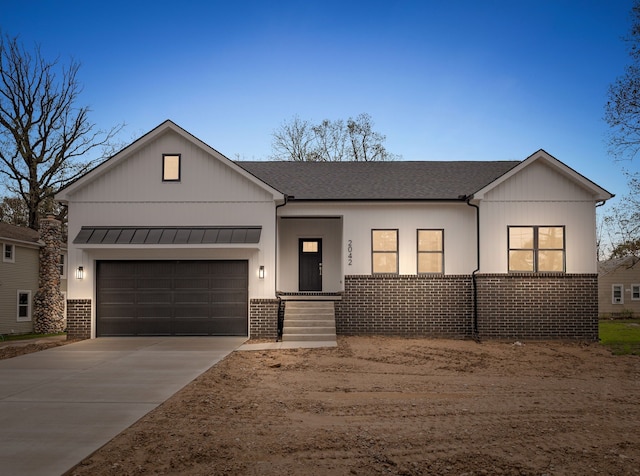 single story home featuring brick siding, concrete driveway, an attached garage, and a standing seam roof