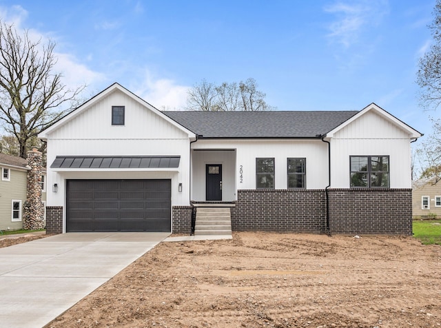 modern inspired farmhouse featuring brick siding, concrete driveway, a standing seam roof, and a shingled roof