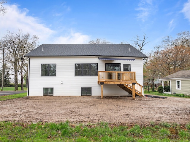back of house featuring stairway, a deck, and a shingled roof
