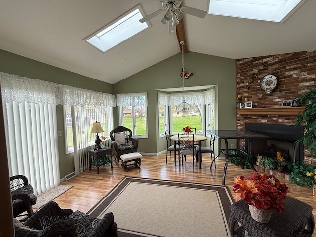 275 Madison St, Port Austin, MI 48467 - living room with lofted ceiling with skylight, a ceiling fan, a healthy amount of sunlight, and wood finished floors