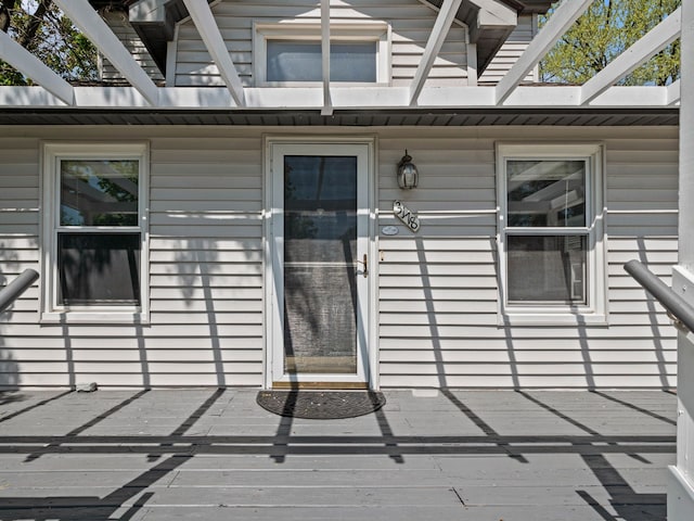 entrance to property featuring a pergola and a wooden deck