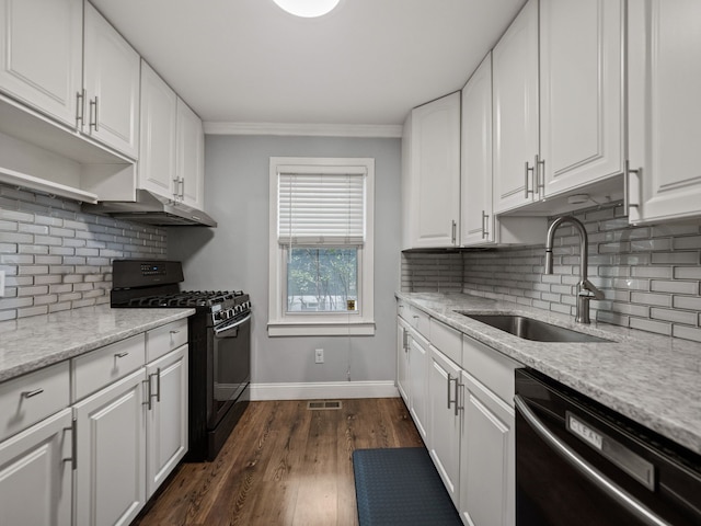 kitchen featuring a sink, black gas range oven, dishwashing machine, under cabinet range hood, and baseboards