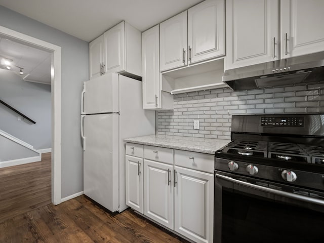 kitchen featuring freestanding refrigerator, baseboards, under cabinet range hood, black gas range, and tasteful backsplash