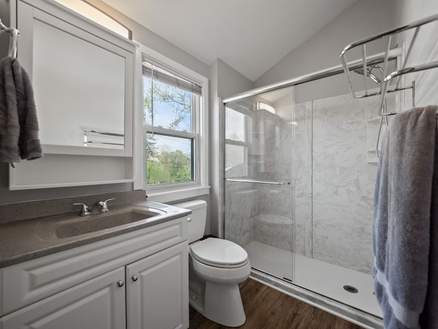 full bathroom with toilet, a marble finish shower, wood finished floors, and lofted ceiling