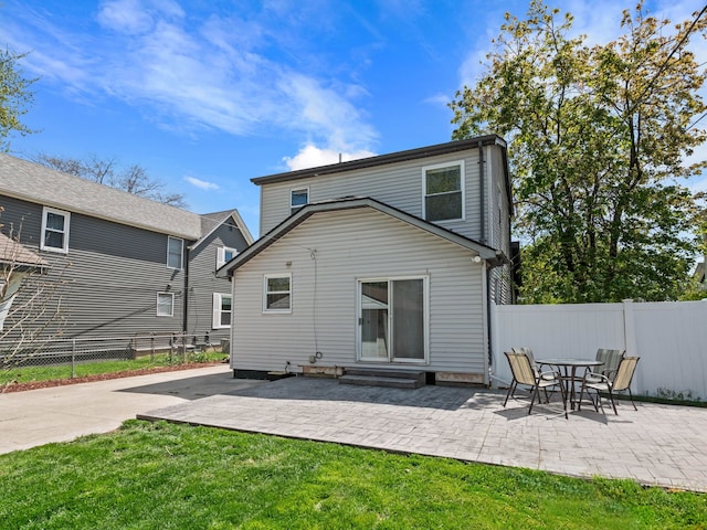 back of house featuring a yard, entry steps, a patio, and fence