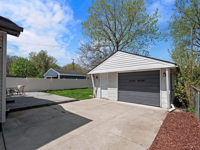 detached garage with driveway and fence