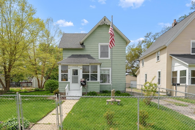 view of front of property featuring a shingled roof, a gate, fence private yard, and a front lawn