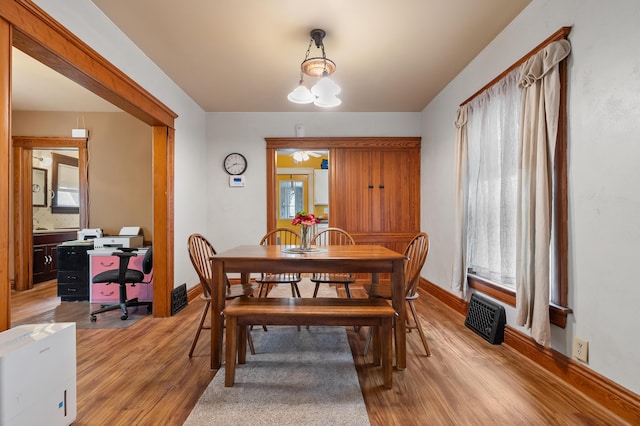 dining area with light wood-style flooring, baseboards, a notable chandelier, and visible vents