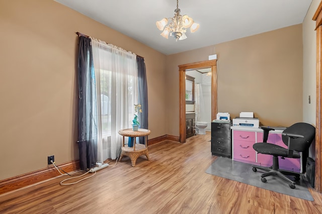 office space with light wood finished floors, an inviting chandelier, and baseboards