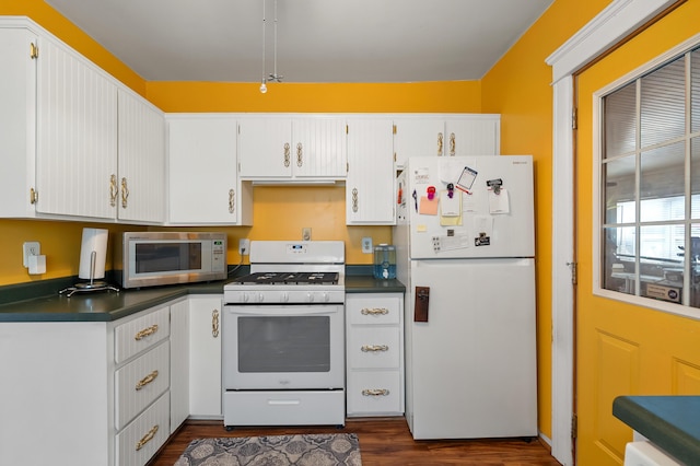 kitchen featuring dark wood-style floors, white appliances, dark countertops, and white cabinets