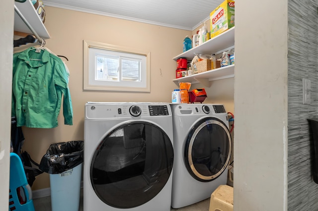 laundry room featuring washing machine and dryer, ornamental molding, and laundry area