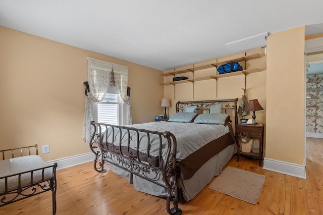 bedroom featuring hardwood / wood-style flooring and baseboards