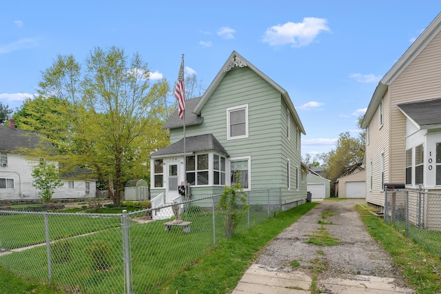 view of front of house with fence private yard, roof with shingles, a front lawn, and an outbuilding