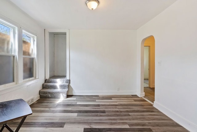 5011 Baldwin Blvd, Flint, MI 48505 - spare room with arched walkways, baseboards, and wood finished floors