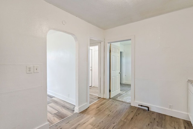 5011 Baldwin Blvd, Flint, MI 48505 - spare room with arched walkways, baseboards, and light wood-style flooring