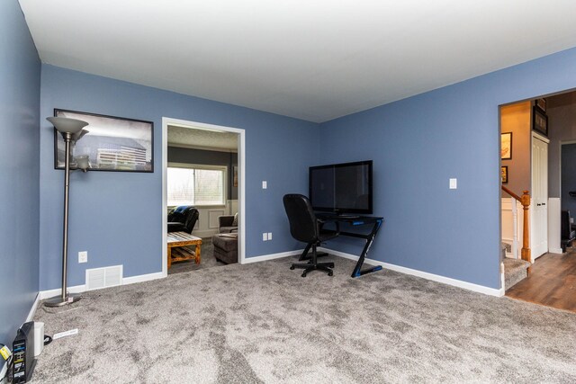 carpeted office space with baseboards and visible vents
