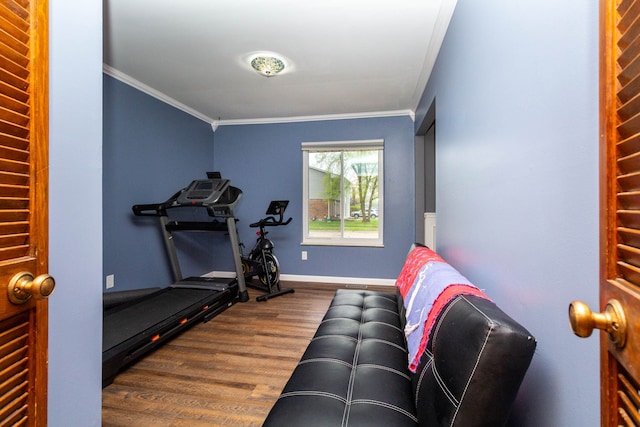 exercise room with baseboards, crown molding, and wood finished floors