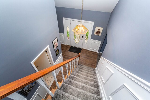 stairs featuring a decorative wall, a wainscoted wall, and wood finished floors