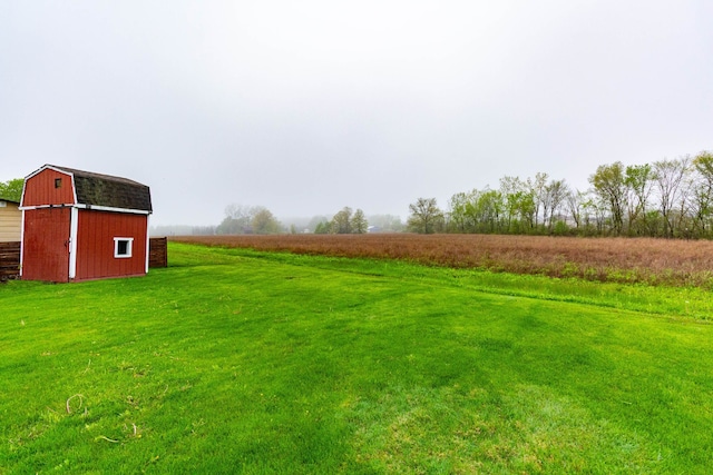 view of yard with a rural view, an outdoor structure, and a barn