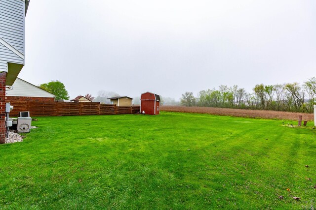 view of yard featuring fence and a barn