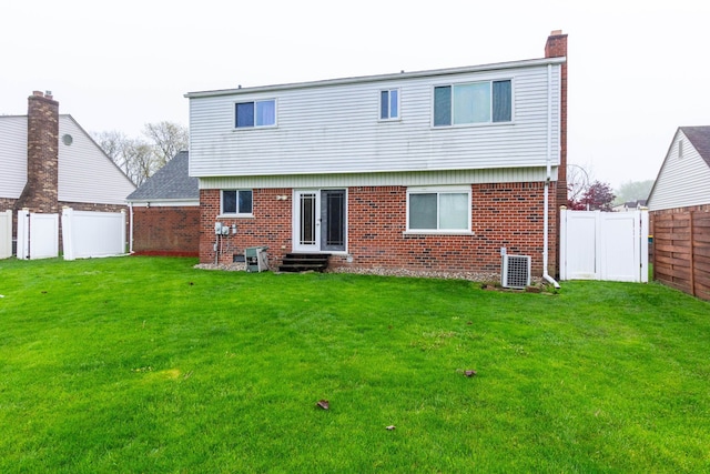 rear view of property with a chimney, entry steps, brick siding, and a fenced backyard